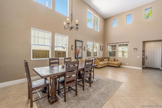 tiled dining space featuring a towering ceiling and an inviting chandelier