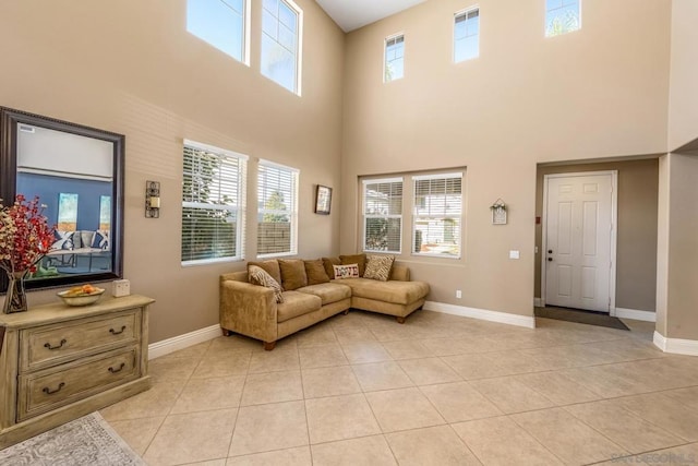 living room with light tile patterned floors and a towering ceiling