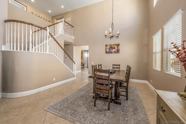 dining space featuring light tile patterned floors, an inviting chandelier, and a high ceiling