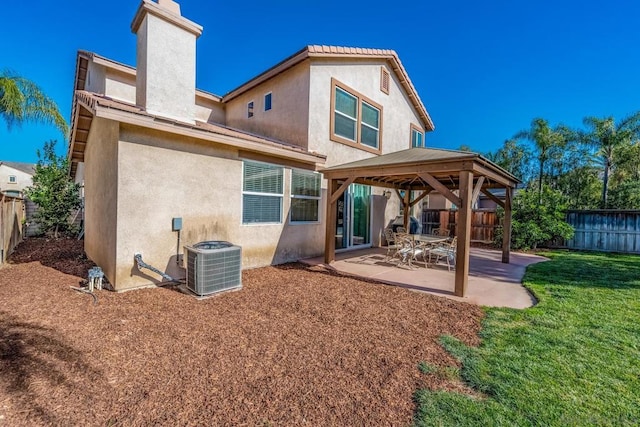 rear view of house featuring a lawn, central AC, a gazebo, and a patio