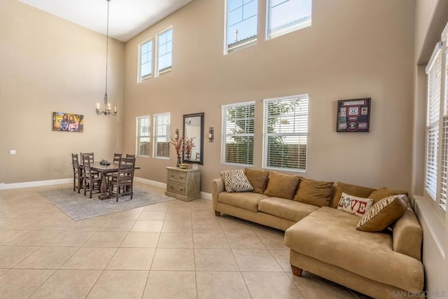 living room featuring light tile patterned floors, a notable chandelier, and a high ceiling