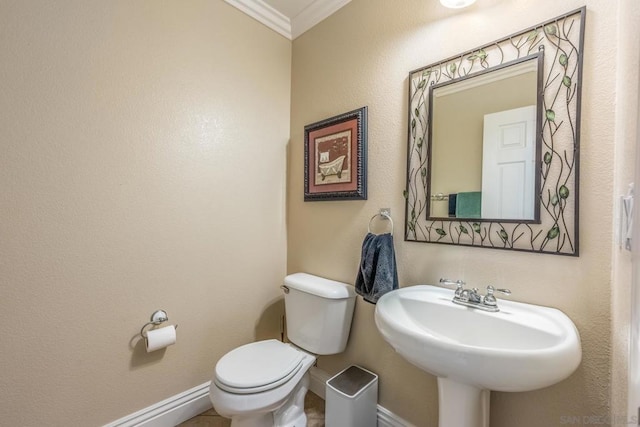 bathroom with toilet, sink, and crown molding