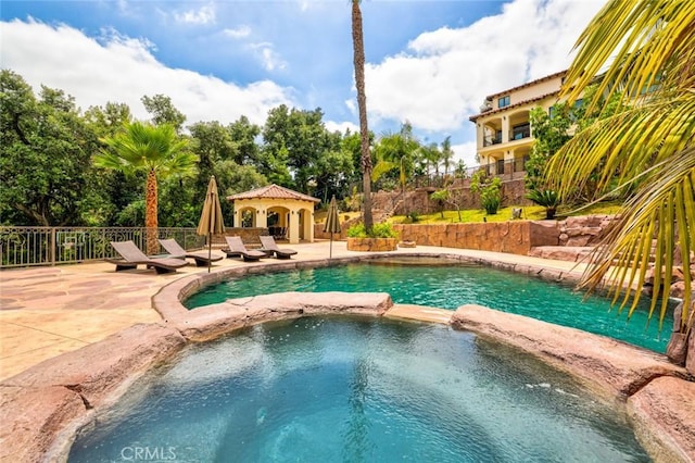 view of pool featuring a patio and an in ground hot tub