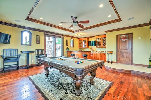 rec room featuring billiards, a raised ceiling, wet bar, crown molding, and ceiling fan