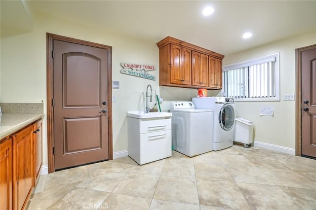 laundry room with cabinets, washer and clothes dryer, and sink