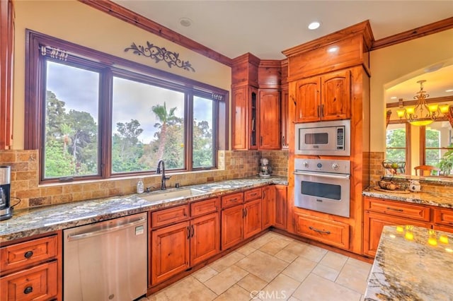 kitchen with decorative backsplash, sink, crown molding, appliances with stainless steel finishes, and light stone counters