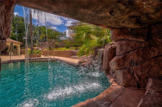 view of swimming pool with pool water feature