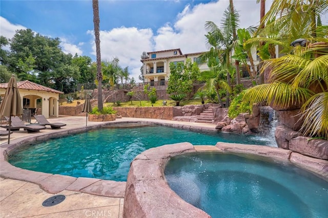 view of pool with a patio area and an in ground hot tub