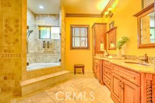 bathroom featuring tile patterned floors, vanity, crown molding, and shower with separate bathtub