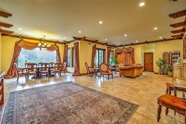 living room with crown molding, a healthy amount of sunlight, and an inviting chandelier