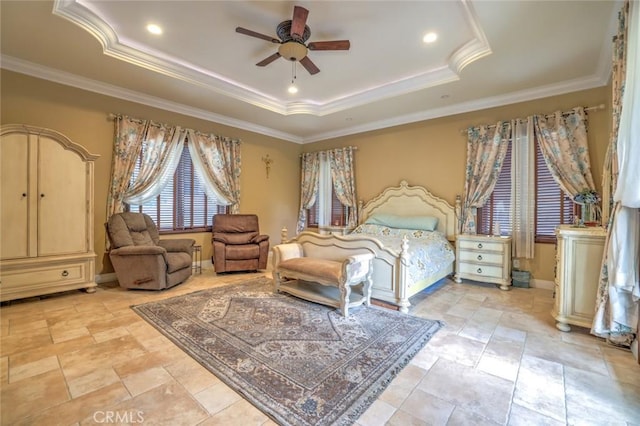 bedroom featuring a tray ceiling, crown molding, and baseboards