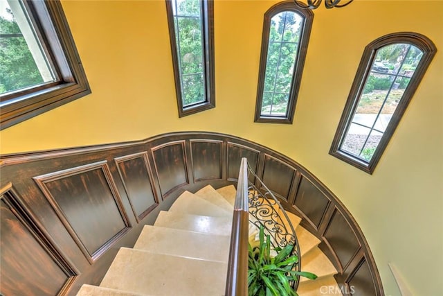 stairway with a notable chandelier