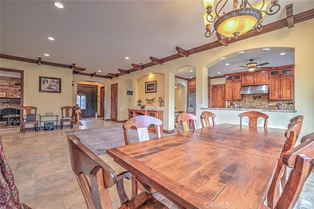 dining space featuring ceiling fan, arched walkways, ornamental molding, and recessed lighting
