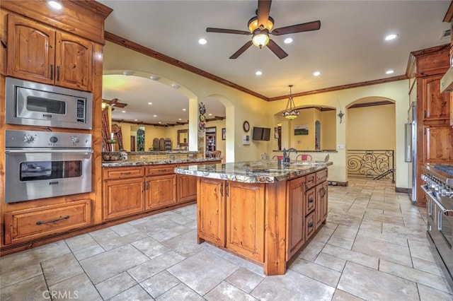 kitchen with crown molding, high quality appliances, and ceiling fan