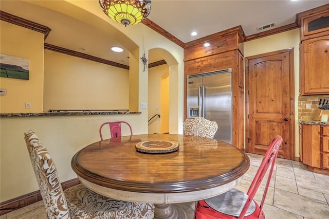 dining area with arched walkways, baseboards, visible vents, recessed lighting, and crown molding