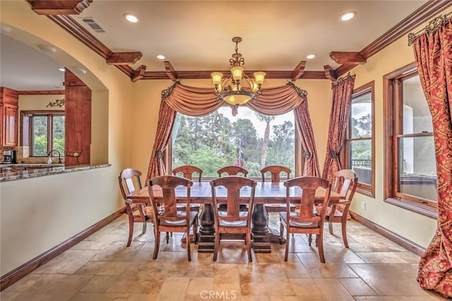 dining space with visible vents, baseboards, a chandelier, and crown molding
