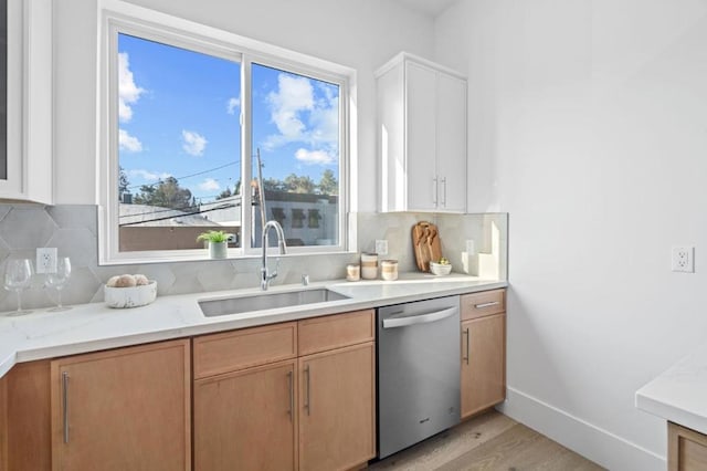 kitchen featuring sink, white cabinetry, tasteful backsplash, light wood-type flooring, and dishwasher