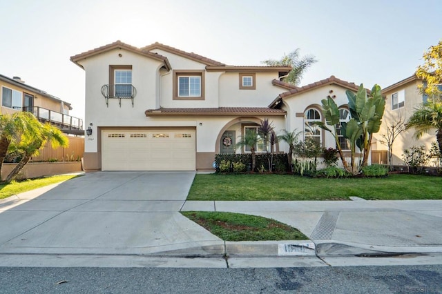 mediterranean / spanish-style home featuring a front lawn and a garage