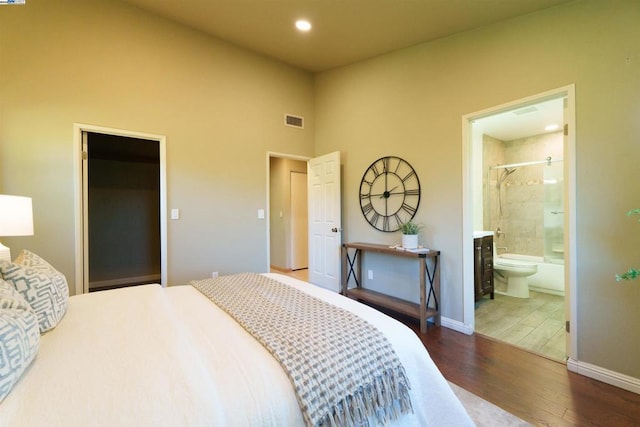 bedroom featuring hardwood / wood-style flooring and ensuite bath