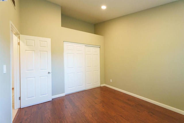 unfurnished bedroom featuring dark hardwood / wood-style floors and a closet