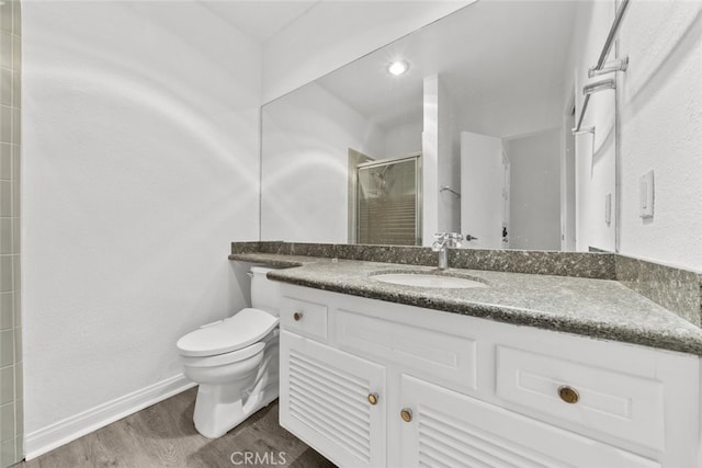 bathroom with an enclosed shower, vanity, wood-type flooring, and toilet