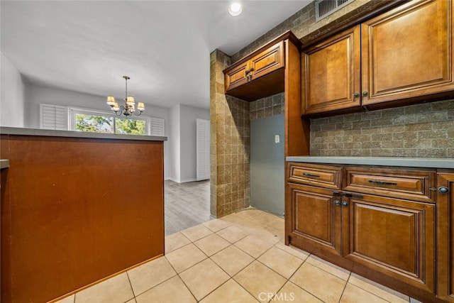 kitchen featuring pendant lighting, light tile patterned floors, and a chandelier