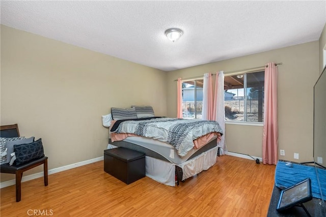 bedroom with wood-type flooring and a textured ceiling