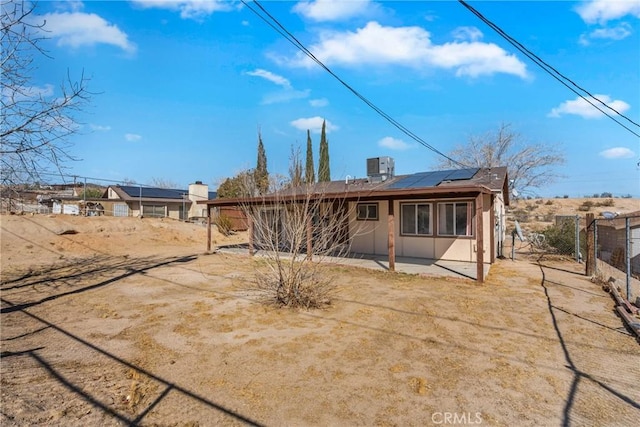 rear view of house with a patio, cooling unit, and solar panels