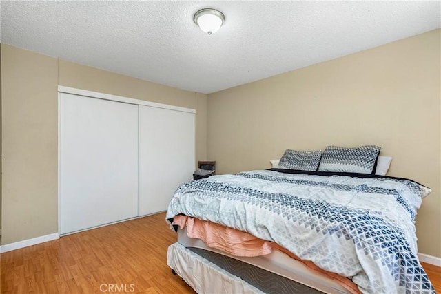 bedroom featuring hardwood / wood-style flooring, a closet, and a textured ceiling