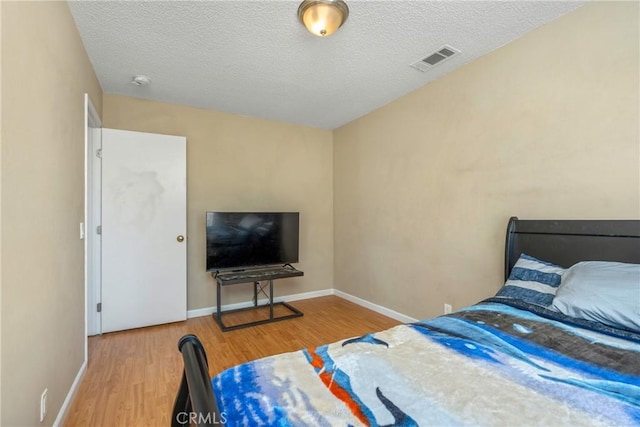 bedroom featuring wood-type flooring and a textured ceiling