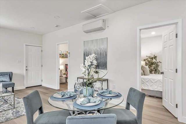 dining space featuring a wall mounted AC and light hardwood / wood-style flooring