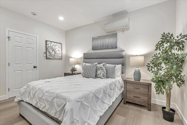 bedroom featuring a wall mounted air conditioner and light wood-type flooring