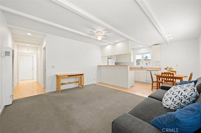 living room with light carpet, beamed ceiling, and ceiling fan