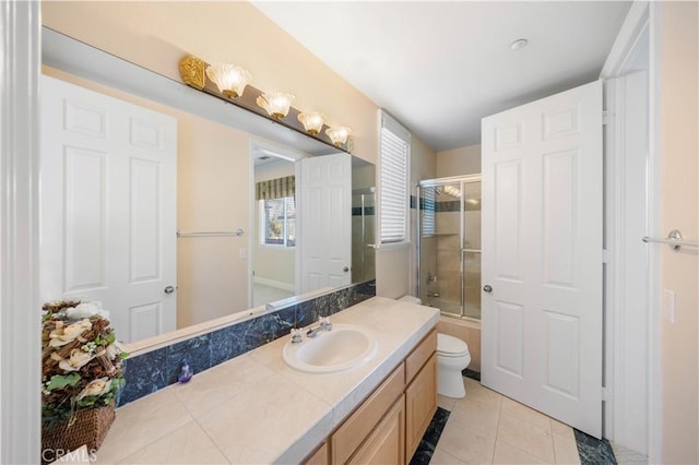 full bathroom featuring bath / shower combo with glass door, tile patterned floors, toilet, and vanity