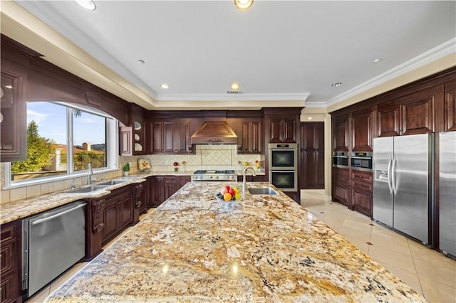 kitchen with light tile patterned floors, custom exhaust hood, appliances with stainless steel finishes, ornamental molding, and sink