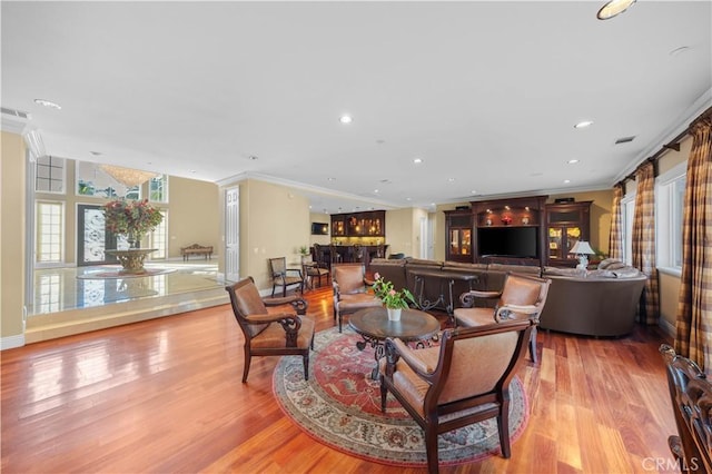 living room with light wood-type flooring and crown molding