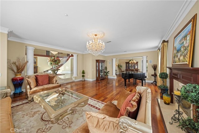 living room with a notable chandelier, wood-type flooring, crown molding, a high end fireplace, and decorative columns