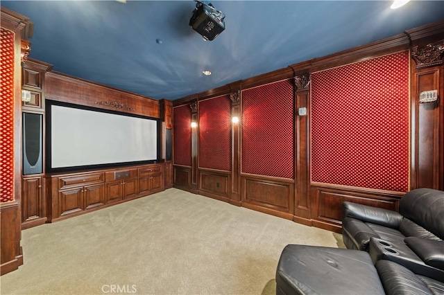 home theater featuring wood walls, light colored carpet, and crown molding