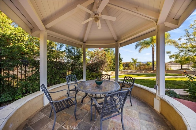 sunroom featuring ceiling fan and beam ceiling