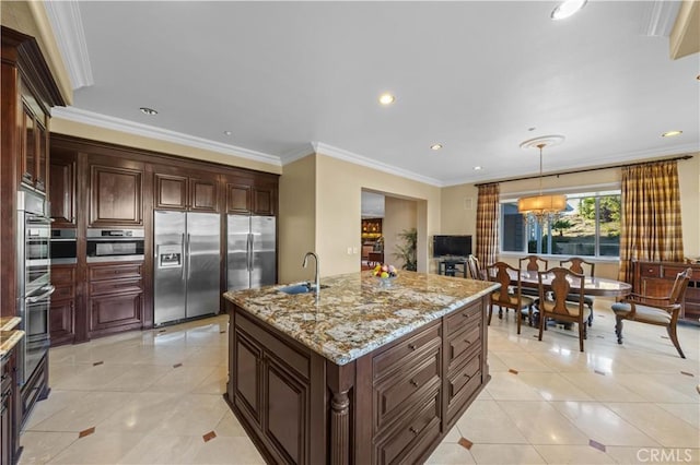 kitchen with decorative light fixtures, sink, a kitchen island with sink, stainless steel fridge with ice dispenser, and ornamental molding