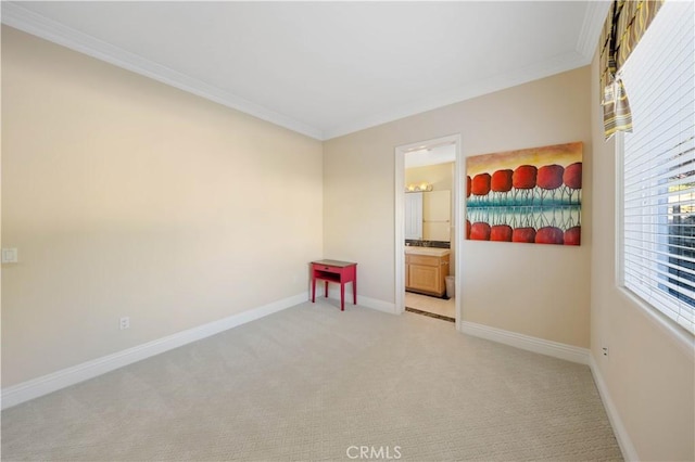 spare room with ornamental molding and light carpet