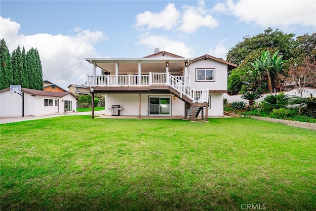 back of property featuring a wooden deck and a lawn