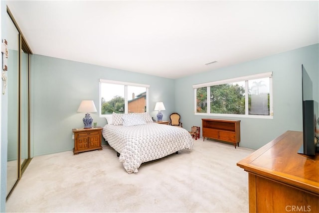 bedroom with carpet floors and multiple windows