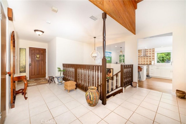 hallway featuring light tile patterned floors and an inviting chandelier