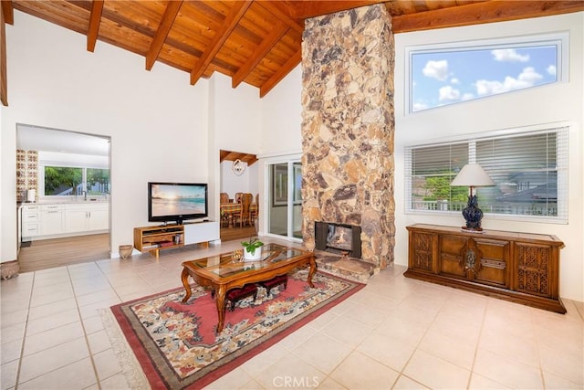 living room featuring a fireplace, beam ceiling, light tile patterned flooring, wood ceiling, and high vaulted ceiling