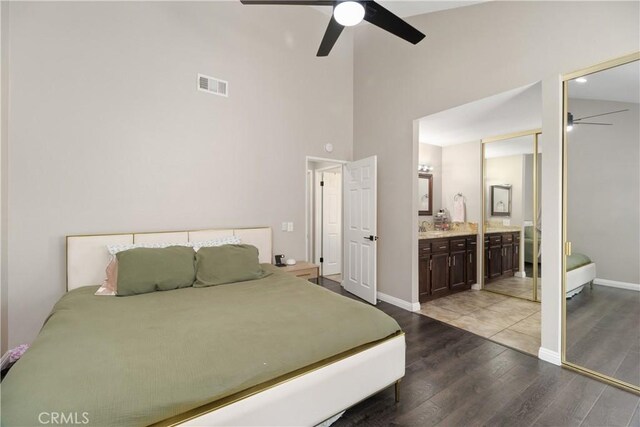 bedroom featuring connected bathroom, wood-type flooring, sink, a high ceiling, and ceiling fan