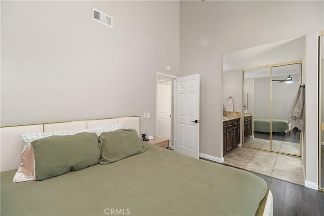 bedroom featuring light wood-type flooring, a closet, and a high ceiling