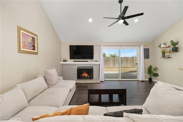 living room featuring hardwood / wood-style flooring, ceiling fan, lofted ceiling, and a fireplace