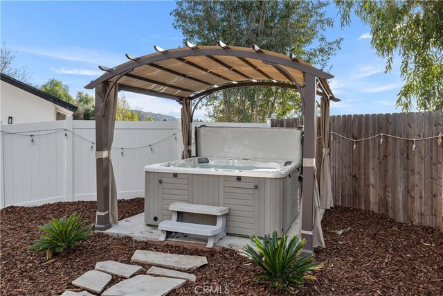 view of patio with a hot tub and a pergola