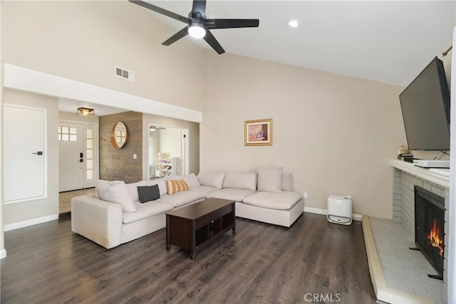 living room with ceiling fan, dark wood-type flooring, and a fireplace